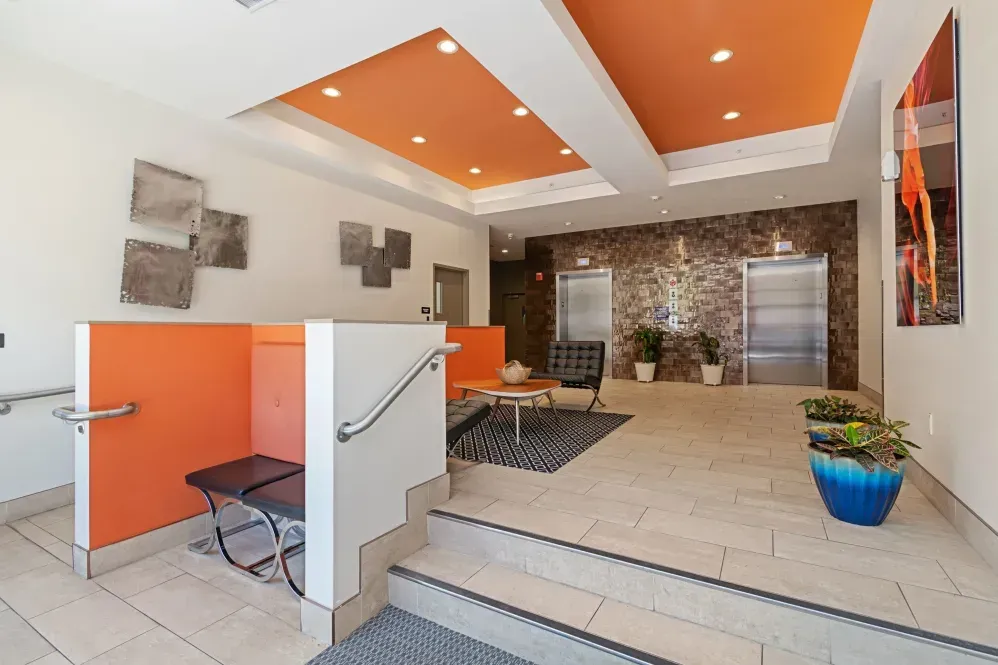 A large lobby with stairs leading up to the elevators.