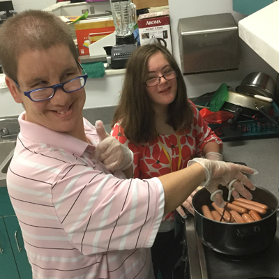 two young adults cooking