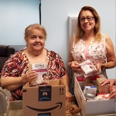 Two women preparing gift boxes. 