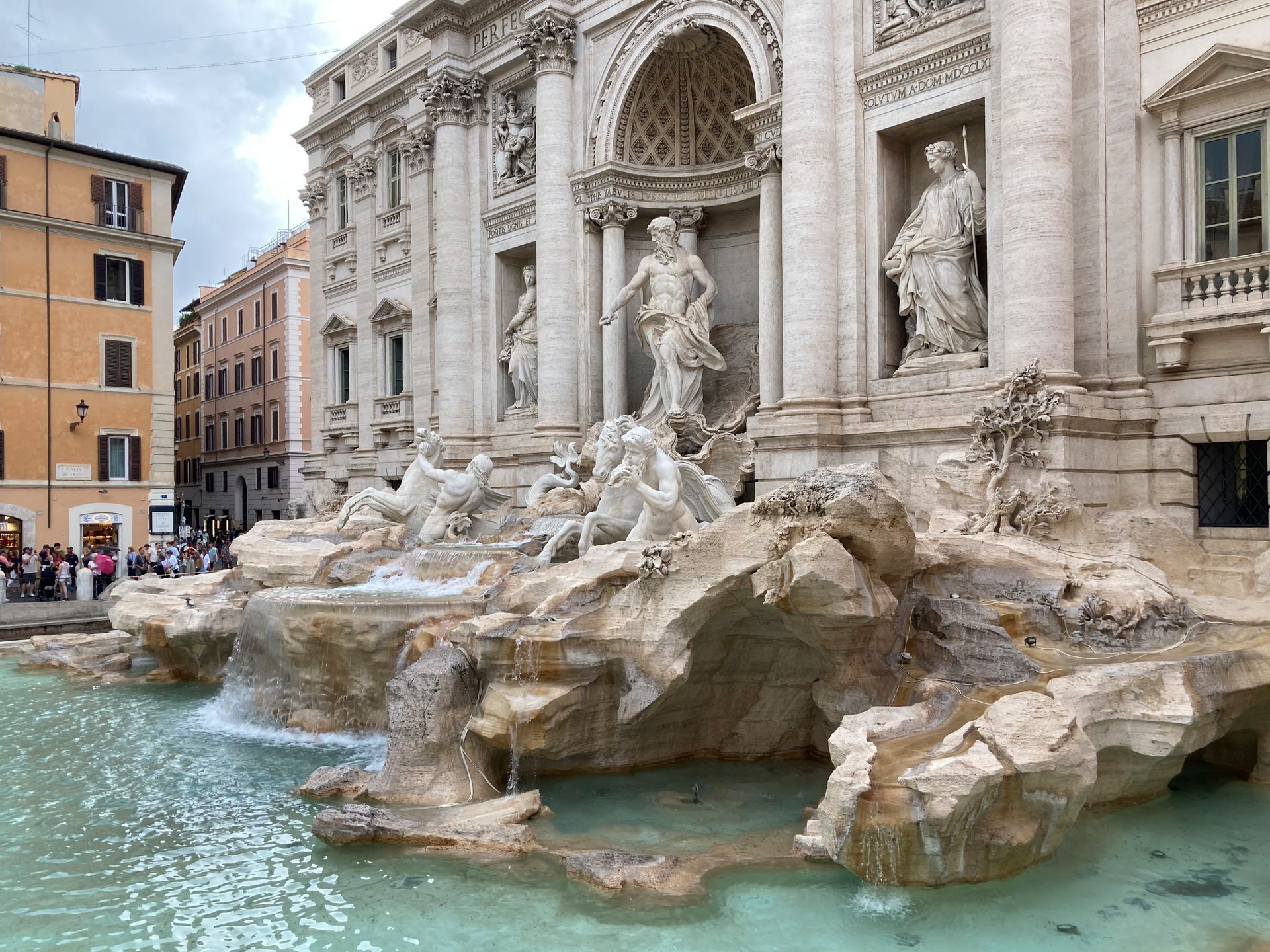 Trevi Fountain in Rome with turquoise water, ornate marble sculptures, and a historic building facade