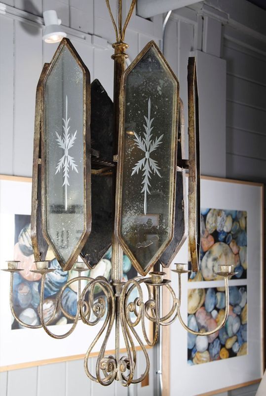 Vintage brass chandelier with mirrored glass panels and white starburst etching, hanging indoors