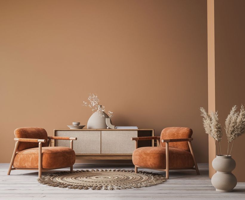 Modern beige living room with low chair and sofa, woven table, round rug, and dried pampas grass in a vase Modern beige living room with low chair and sofa, woven table, round rug, and dried pampas grass in a vase