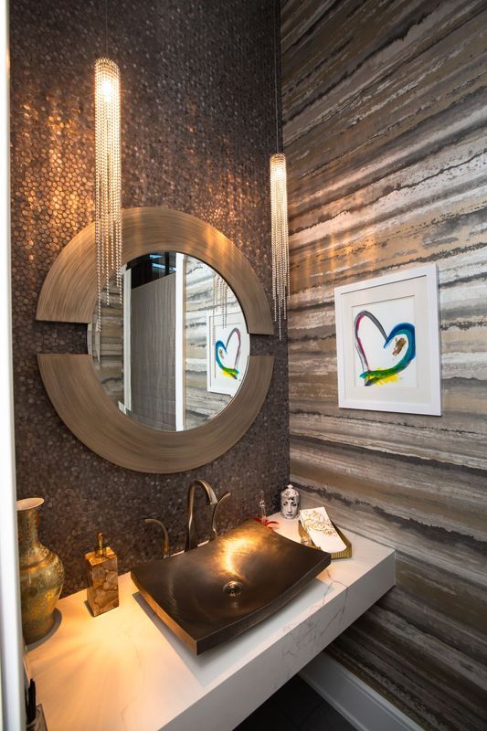 Modern bathroom vanity with round mirror, vessel sink, and striped stone walls