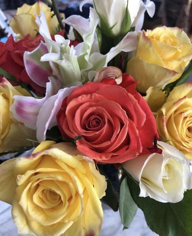 Colorful bouquet of roses in red, yellow, and white, tightly arranged together.
