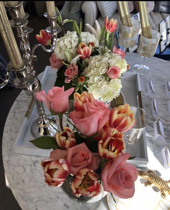Floral centerpiece with pink, white, and red tulips on a silver candelabra table setting