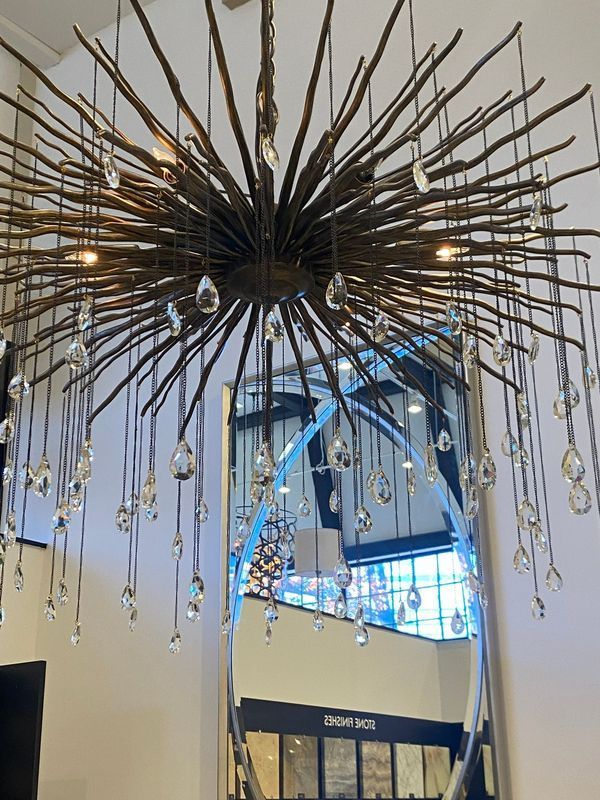 Ceiling chandelier with long gold spikes and hanging crystals in a bright modern interior