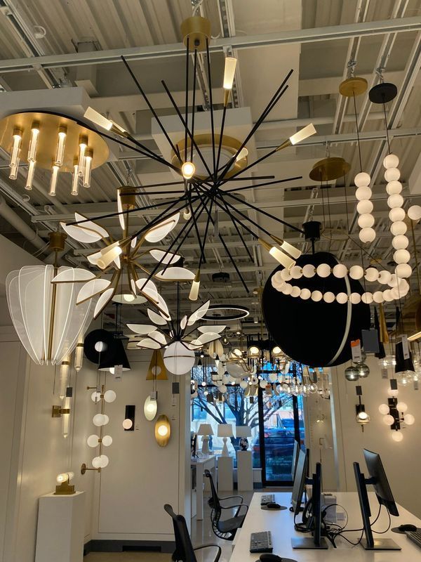 Modern salon interior with hanging pendant lights, styling chairs, and mirrors across a bright room