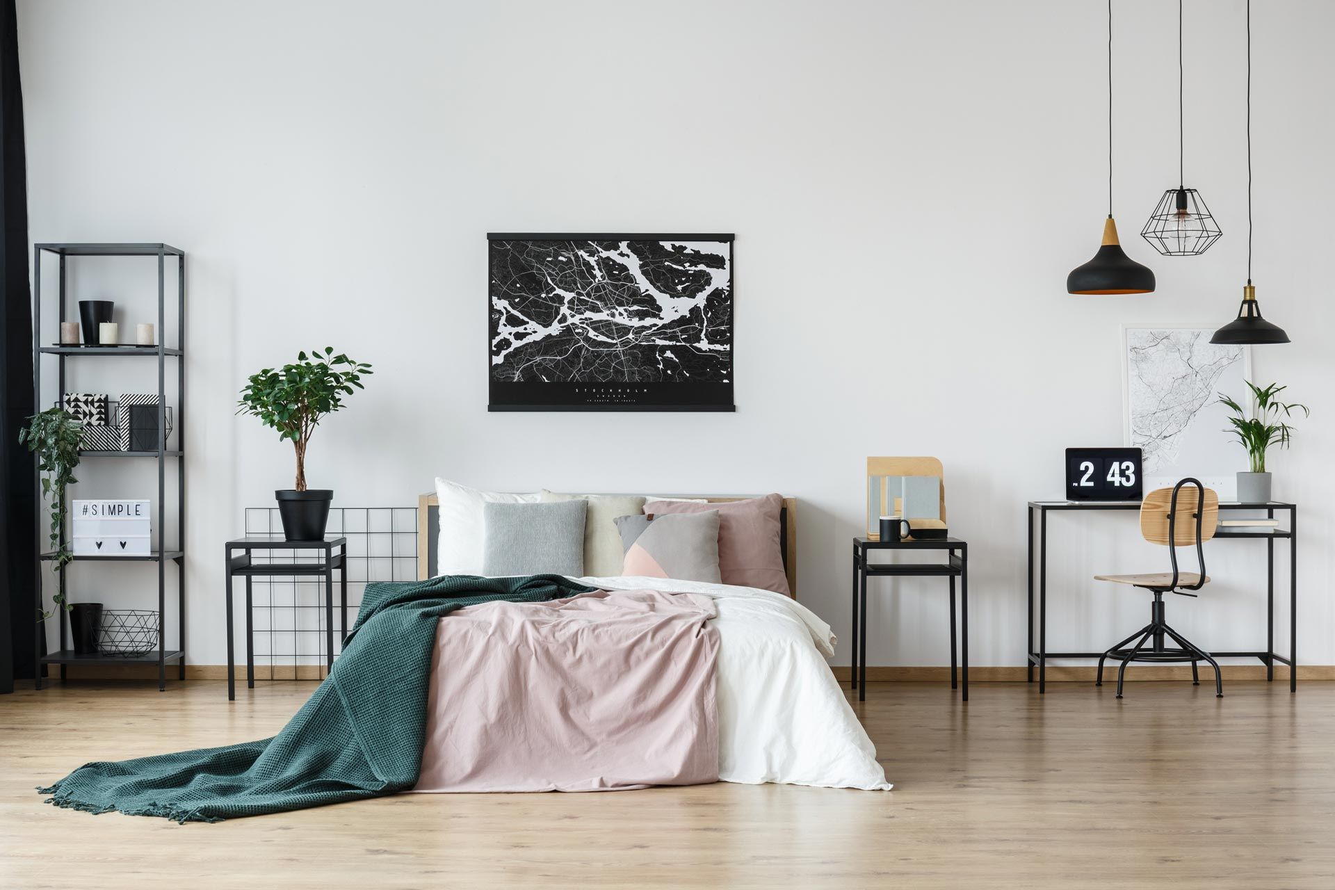 Minimal bedroom with pink bedding, teal throw, black wall art, and wood floor Minimal bedroom with pink bedding, teal throw, black wall art, and wood floor