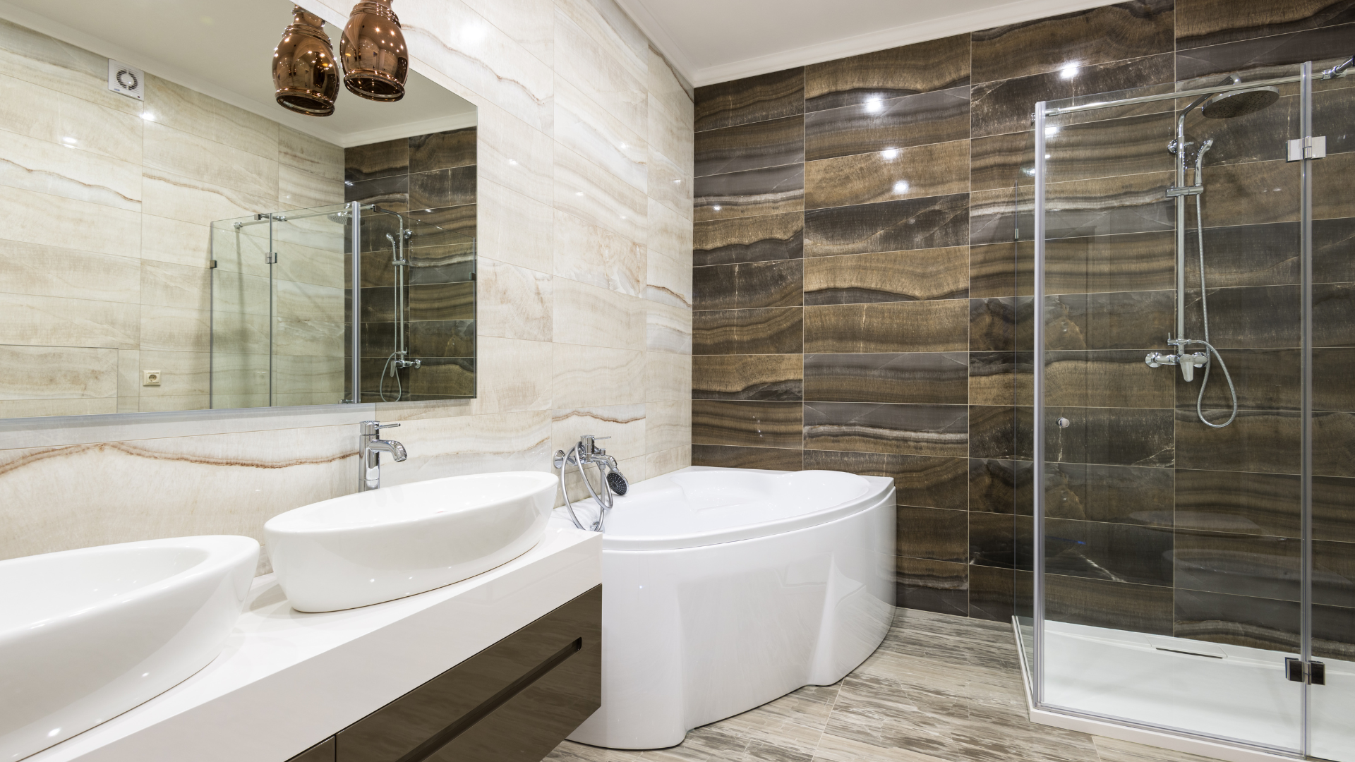 Modern bathroom with double sinks, freestanding tub, and glass-enclosed shower in beige and brown tones