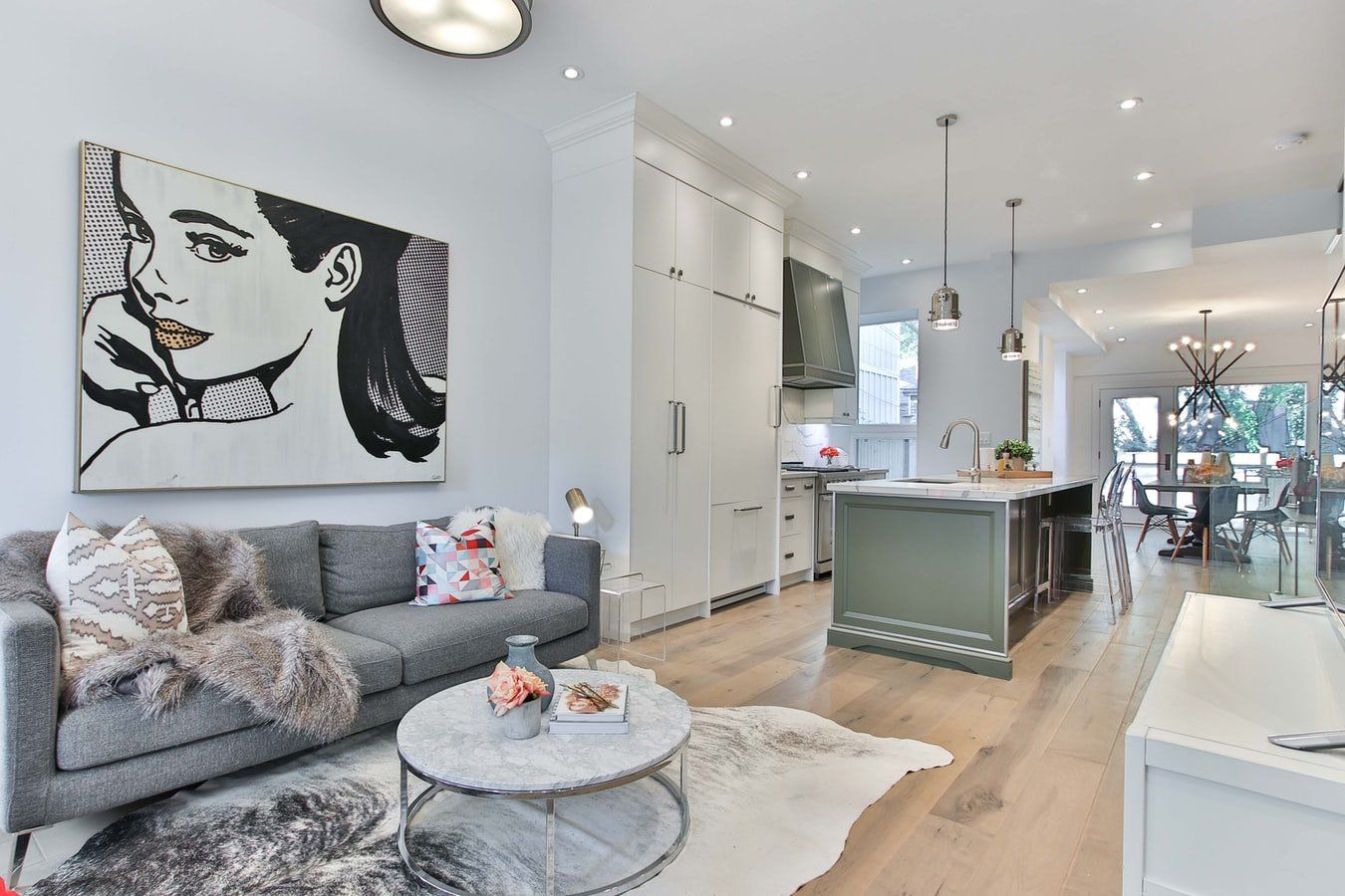 A living room with a couch , coffee table , and painting on the wall.
