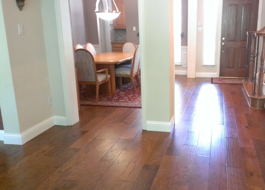 A living room with hardwood floors and a dining room table and chairs.