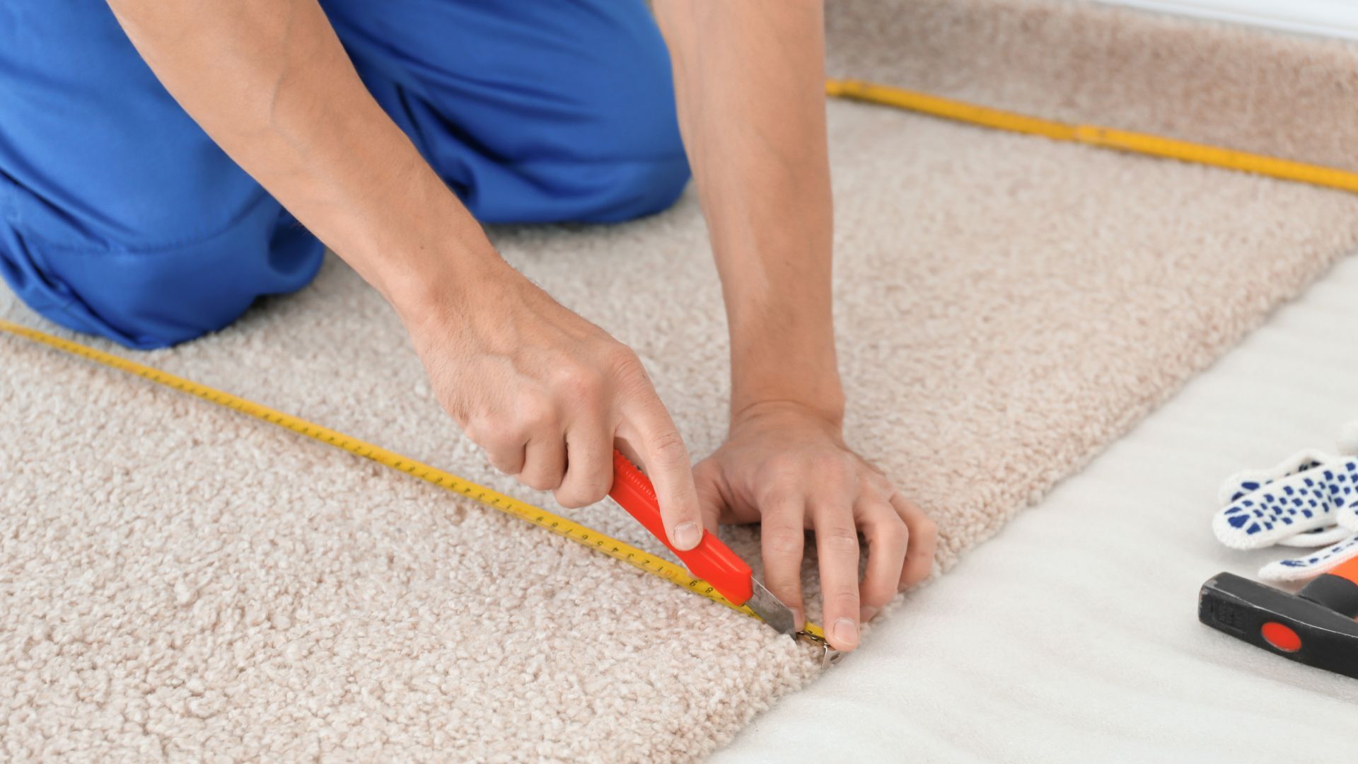A person is measuring a piece of carpet with a tape measure.