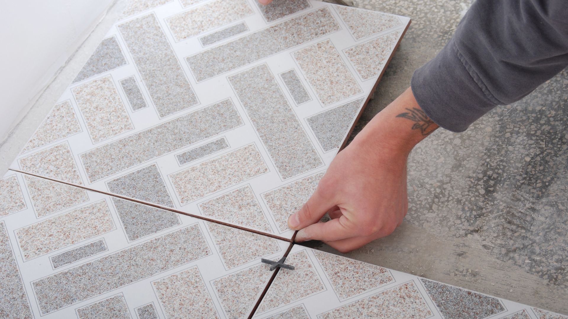 A person is laying a tile on the floor.