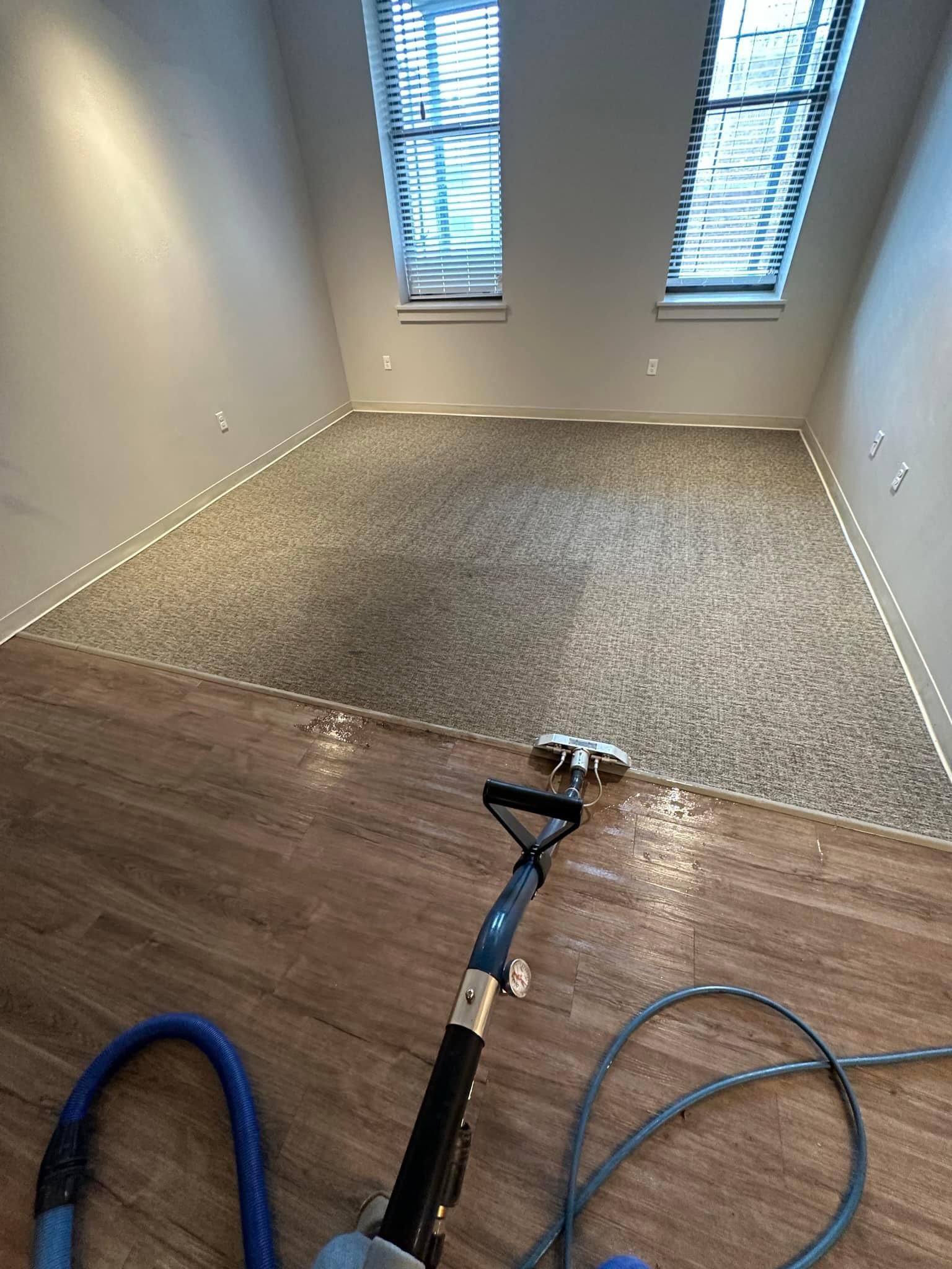 A vacuum cleaner is sitting on a wooden floor in a room.