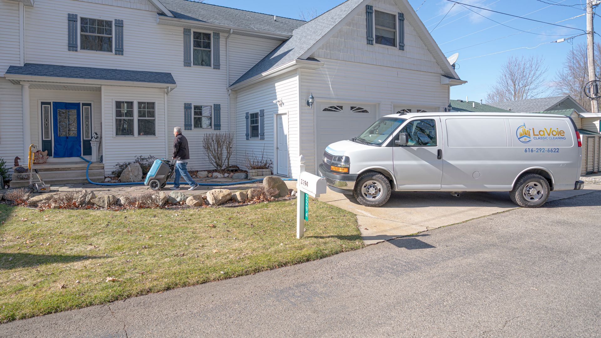 A white van is parked in front of a white house.