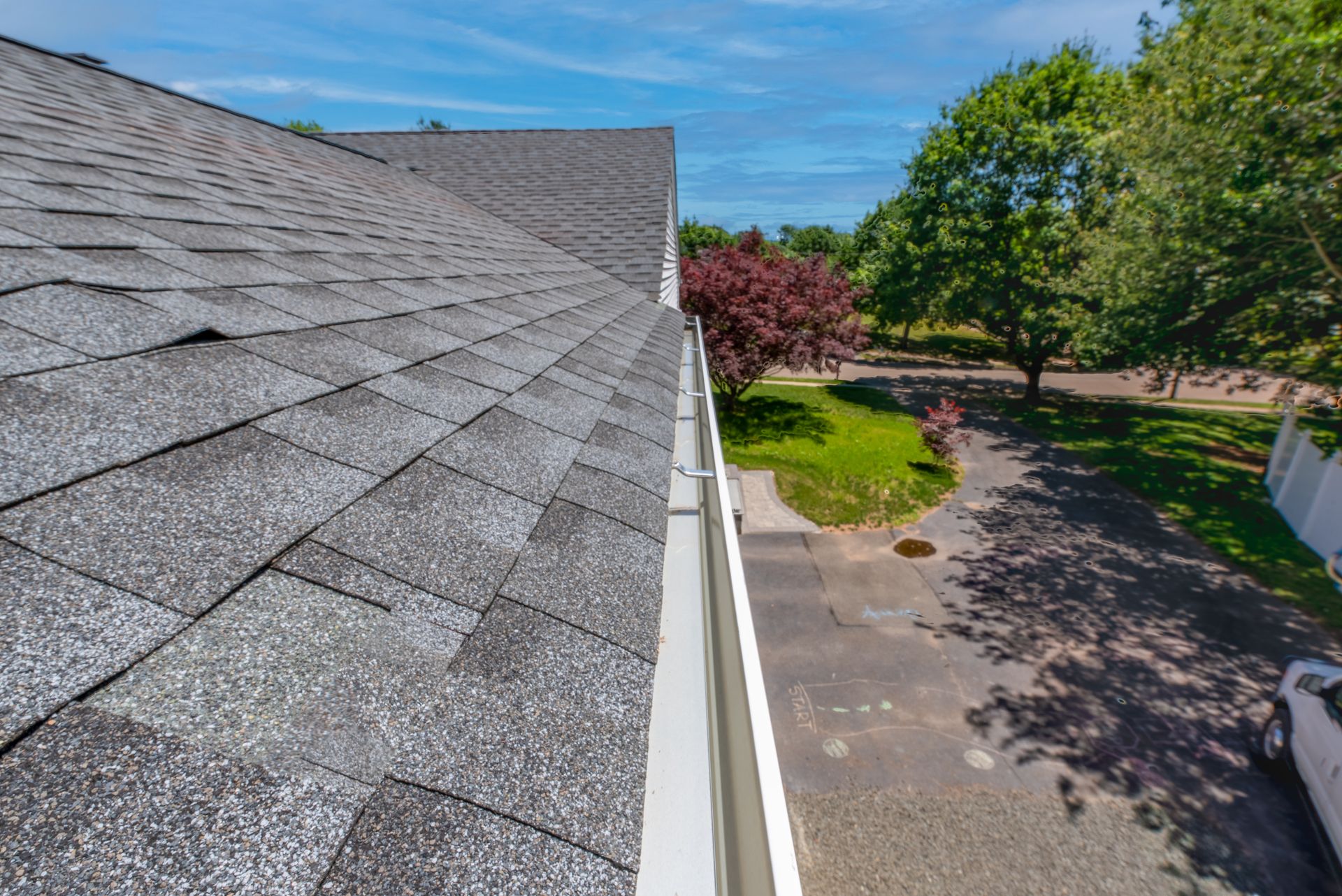 Person using a tool to repair a corrugated metal roof. Sparks fly as they work on the edge of a roof.