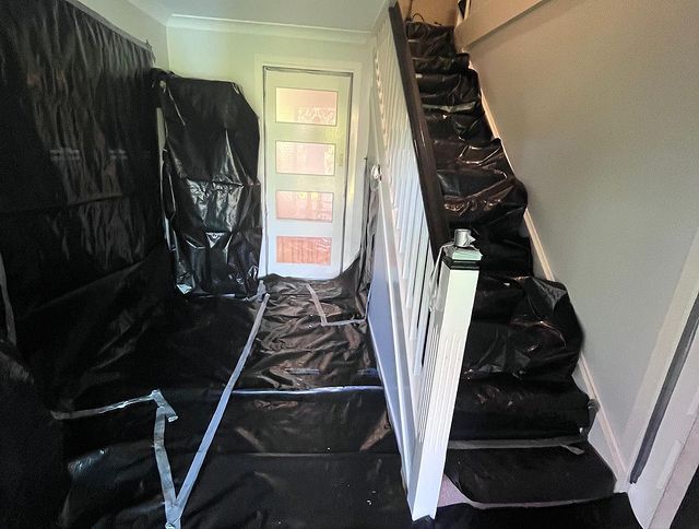 A Hallway with Stairs Covered in Black Plastic — Northern Rivers Demolition & Asbestos in Skennars Head, NSW