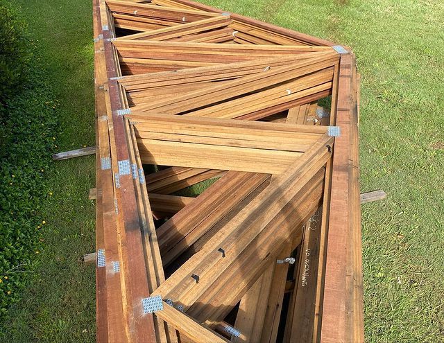 A Stack of Wooden Frames Sitting on Top of A Lush Green Field — Northern Rivers Demolition & Asbestos in Grafton, NSW