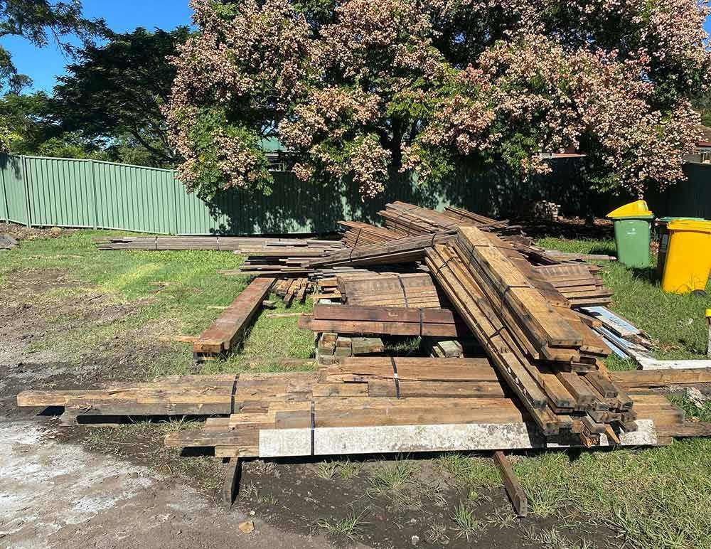 A Pile of Wood Is Laying on The Ground in A Yard — Northern Rivers Demolition & Asbestos in Yamba, NSW