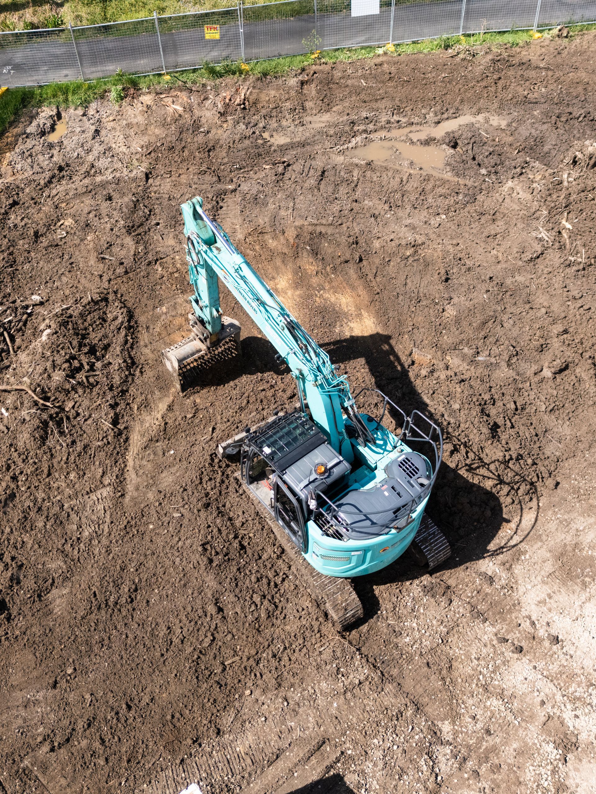 An aerial view of a large excavator in a dirt field.