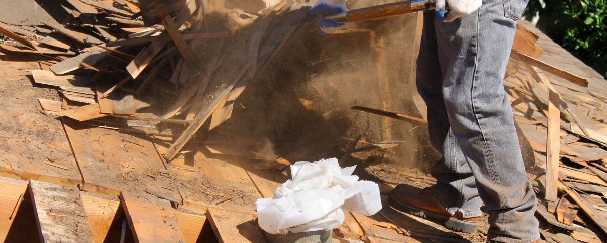 A Man Is Standing on Top of A Wooden Roof — Northern Rivers Demolition & Asbestos in Skennars Head, NSW A Man Is Standing on Top of A Wooden Roof — Northern Rivers Demolition & Asbestos in Skennars Head, NSW