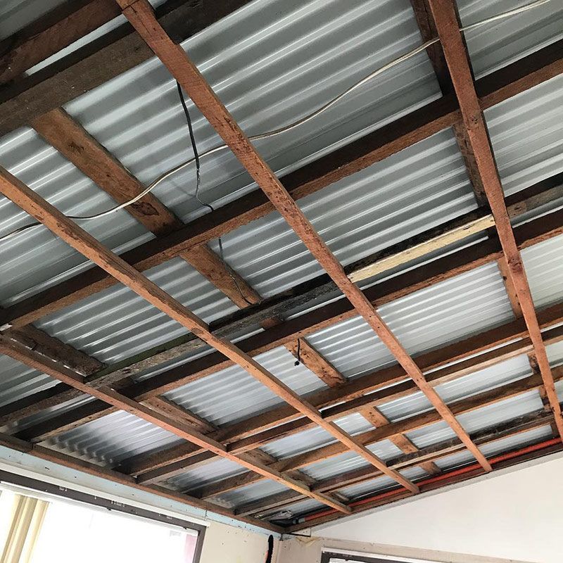 A Ceiling with Wooden Beams and A Metal Roof — Northern Rivers Demolition & Asbestos in Skennars Head, NSW