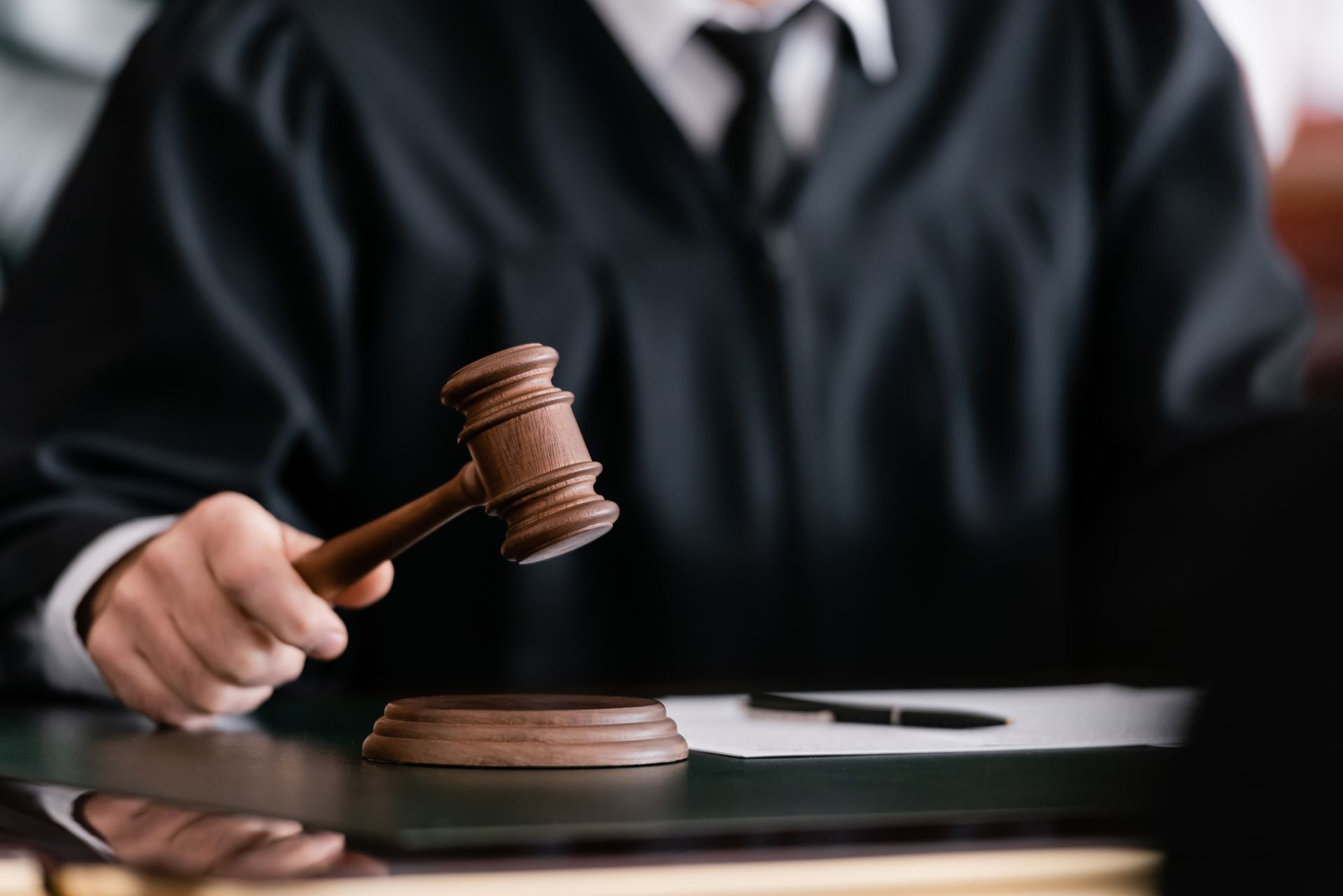 Judge holding a wooden gavel in a courtroom 