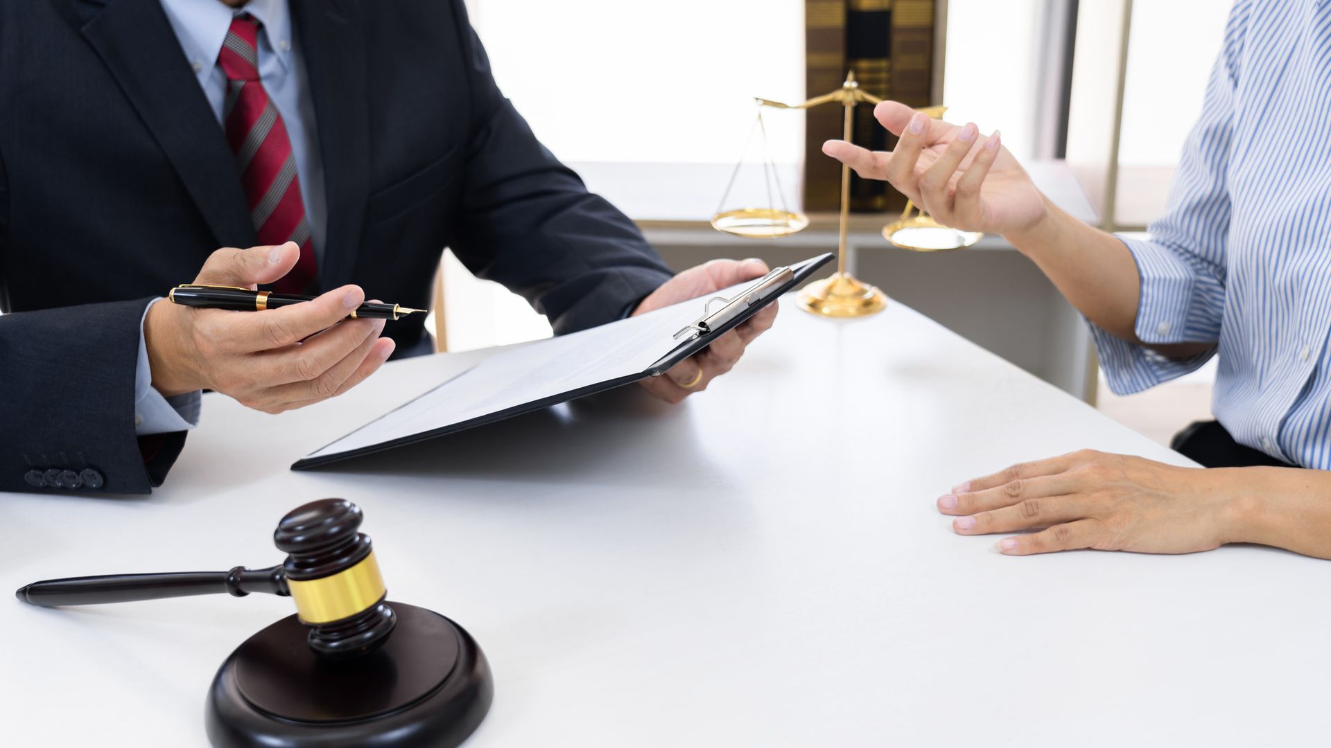 A lawyer working at his office while talking with a client.