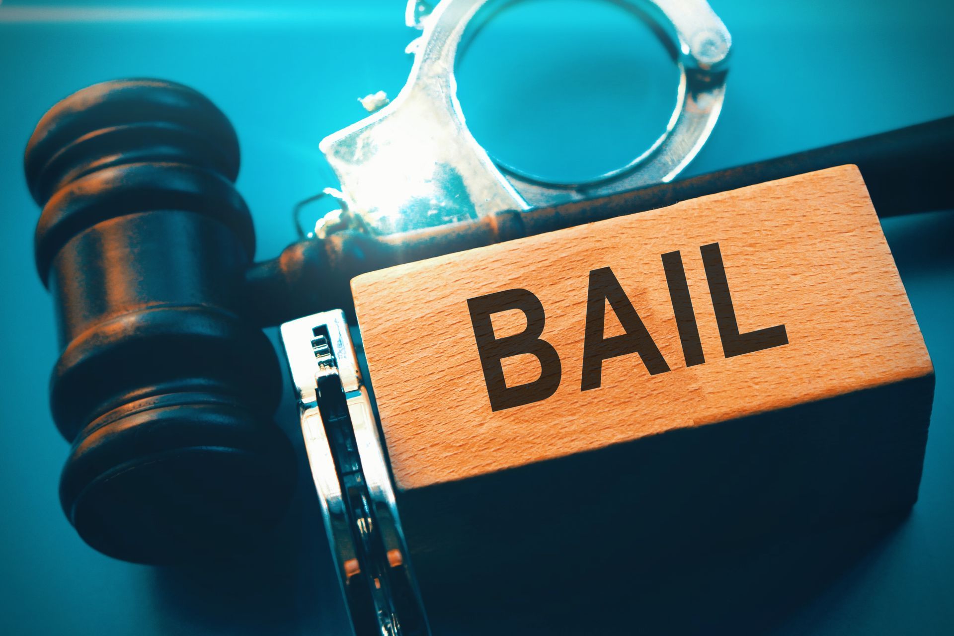 Wooden gavel, handcuffs, and bail sign symbolizing legal process handled by a bail bondsman.