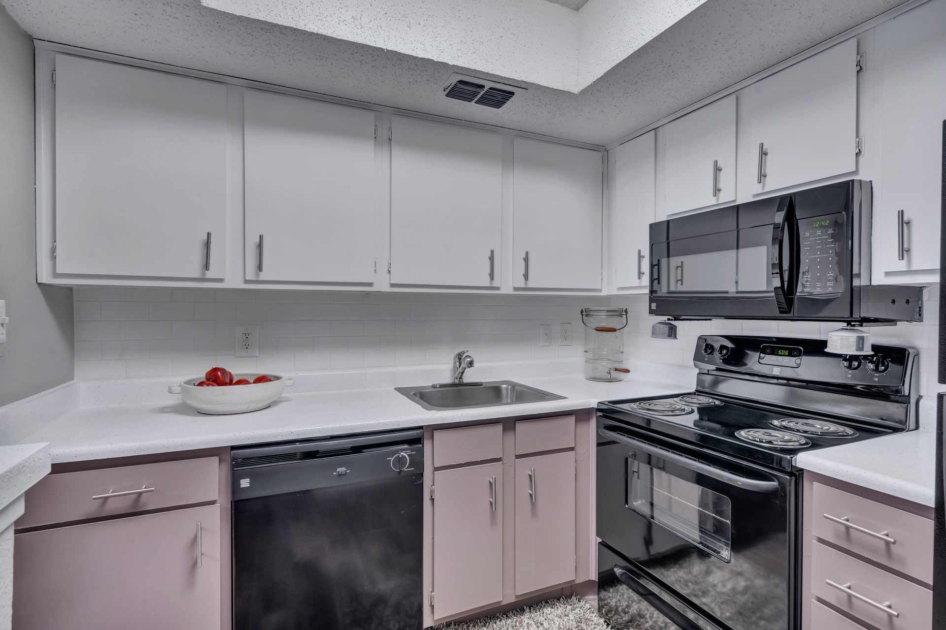A kitchen with pink cabinets and stainless steel appliances