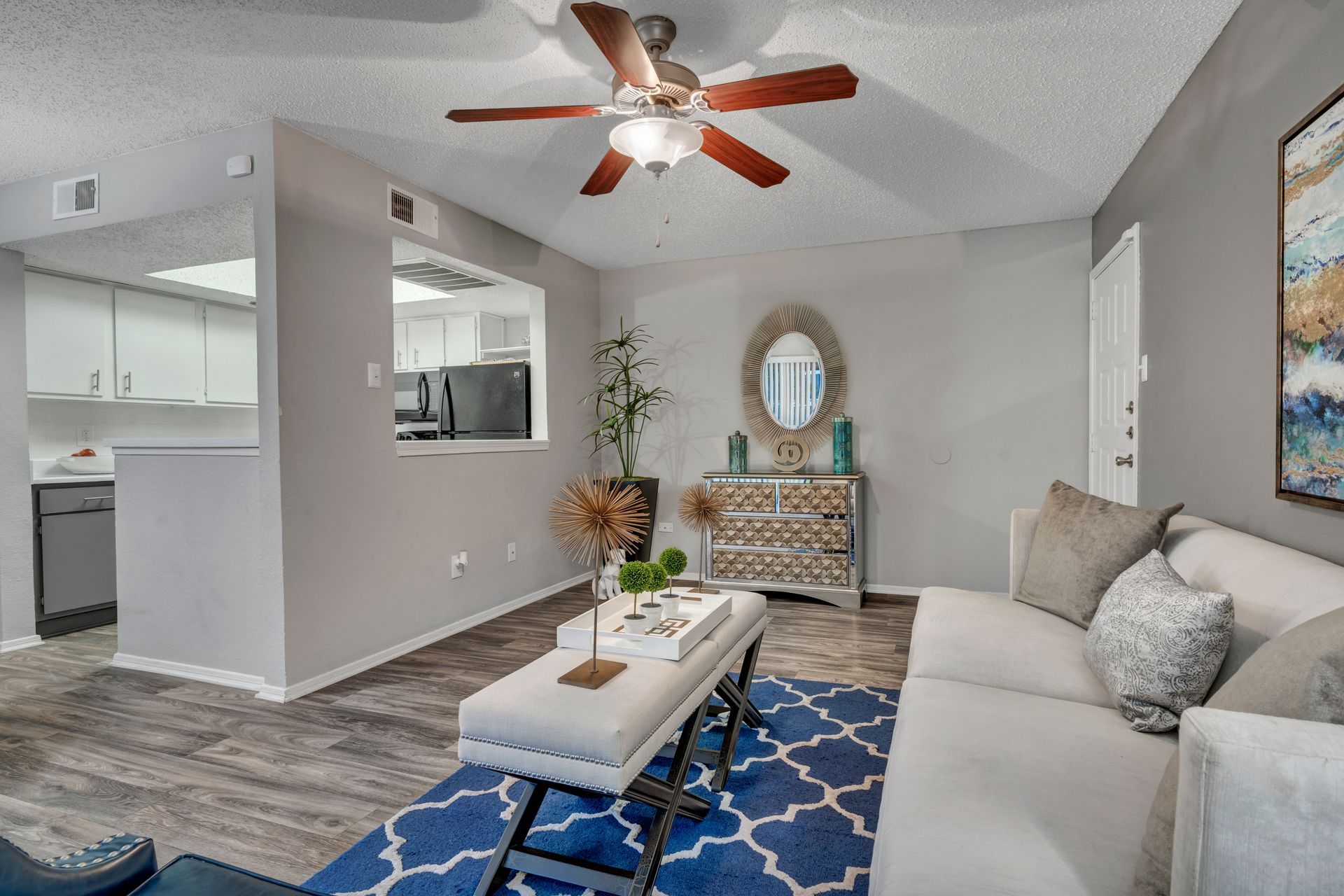 A living room with a couch , coffee table , and ceiling fan.