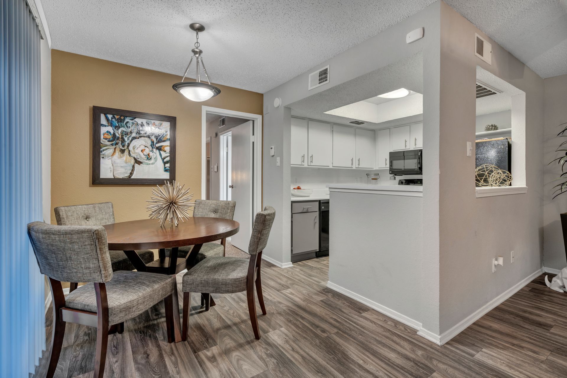 A dining room with a table and chairs next to a kitchen.