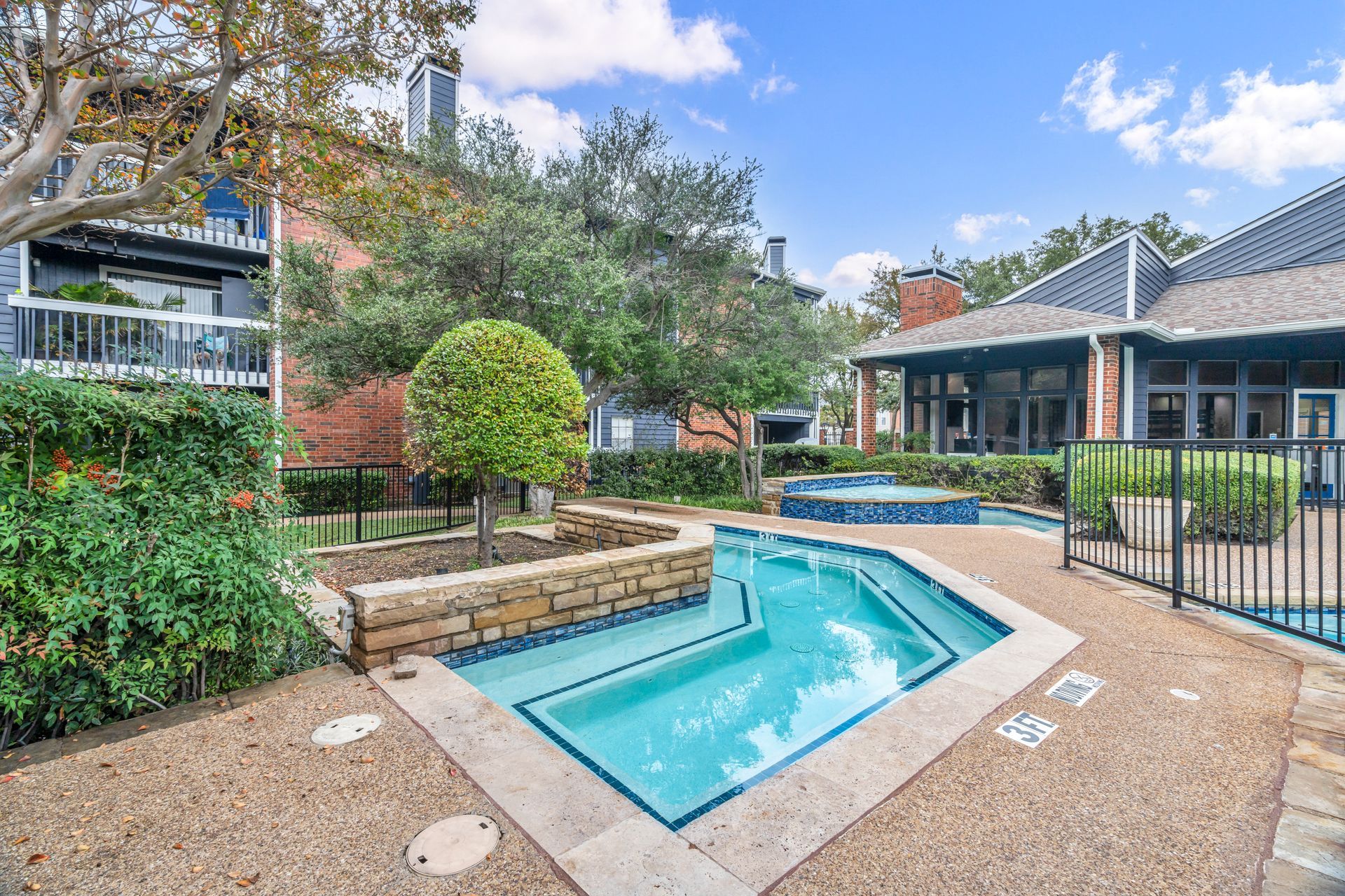 There is a large swimming pool in the middle of a fenced in area.
