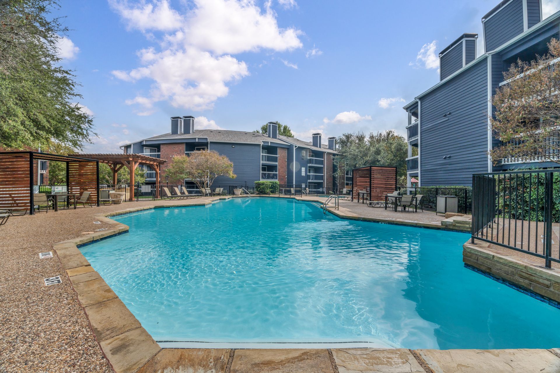 A large swimming pool surrounded by buildings in a residential area.