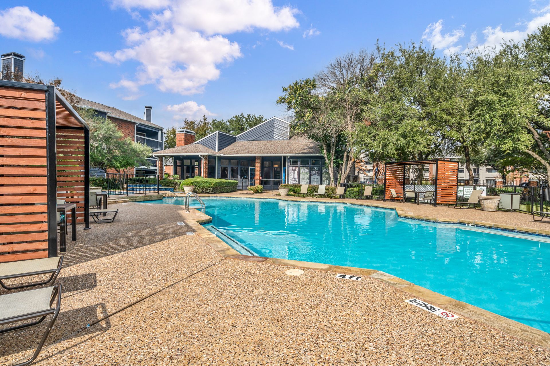 There is a large swimming pool in the middle of a residential area.