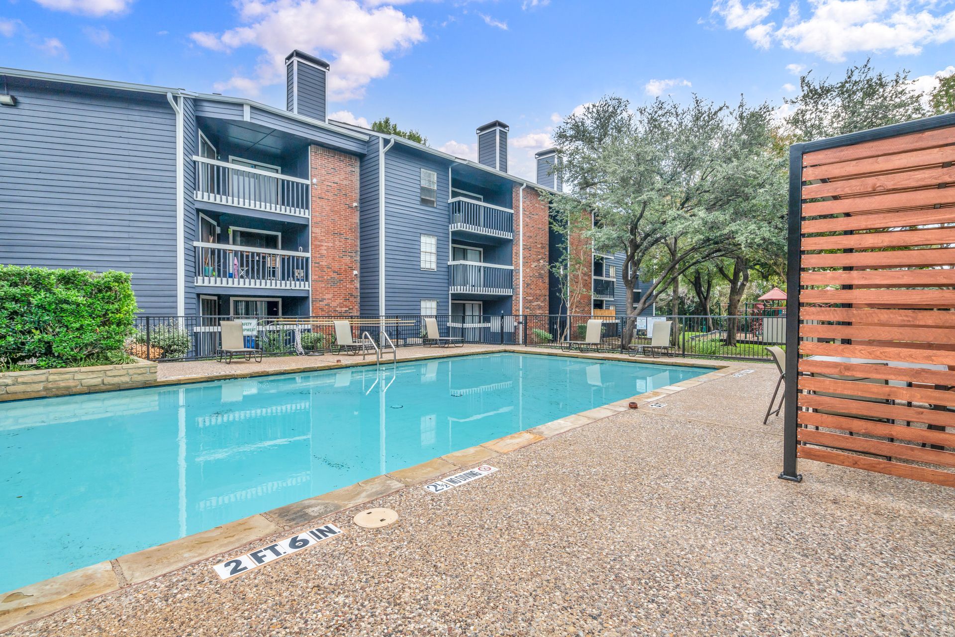 There is a large swimming pool in front of a building.