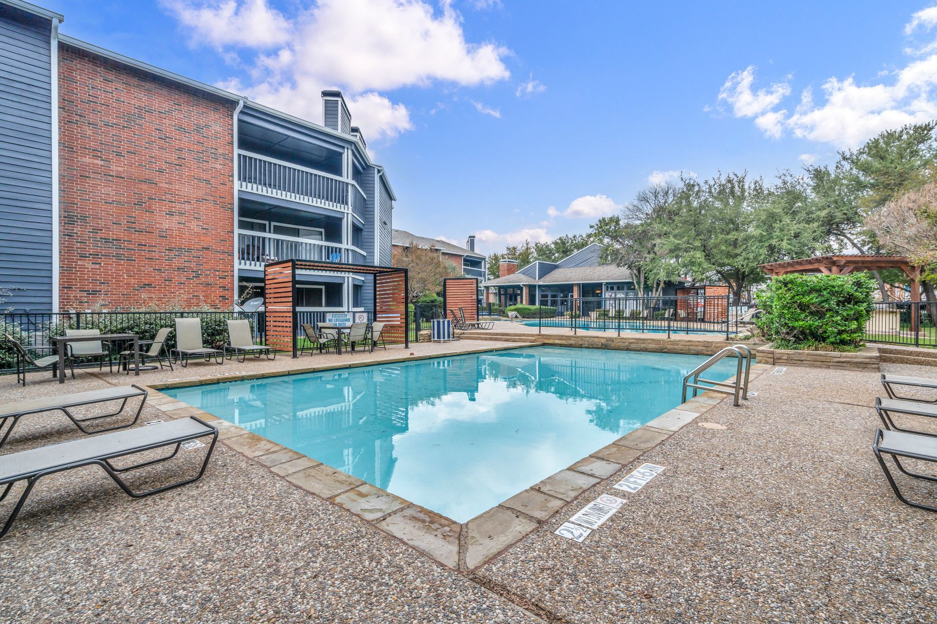 There is a large swimming pool in the middle of a residential area.