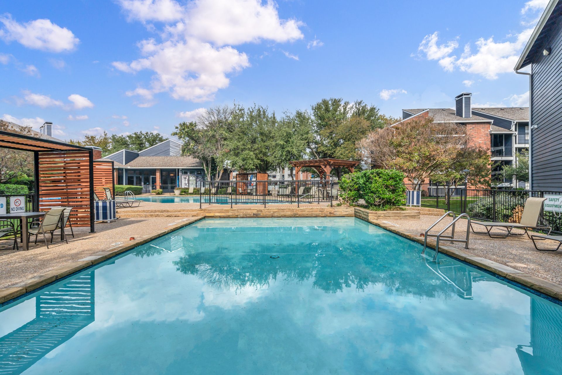 There is a large swimming pool in the middle of a residential area.