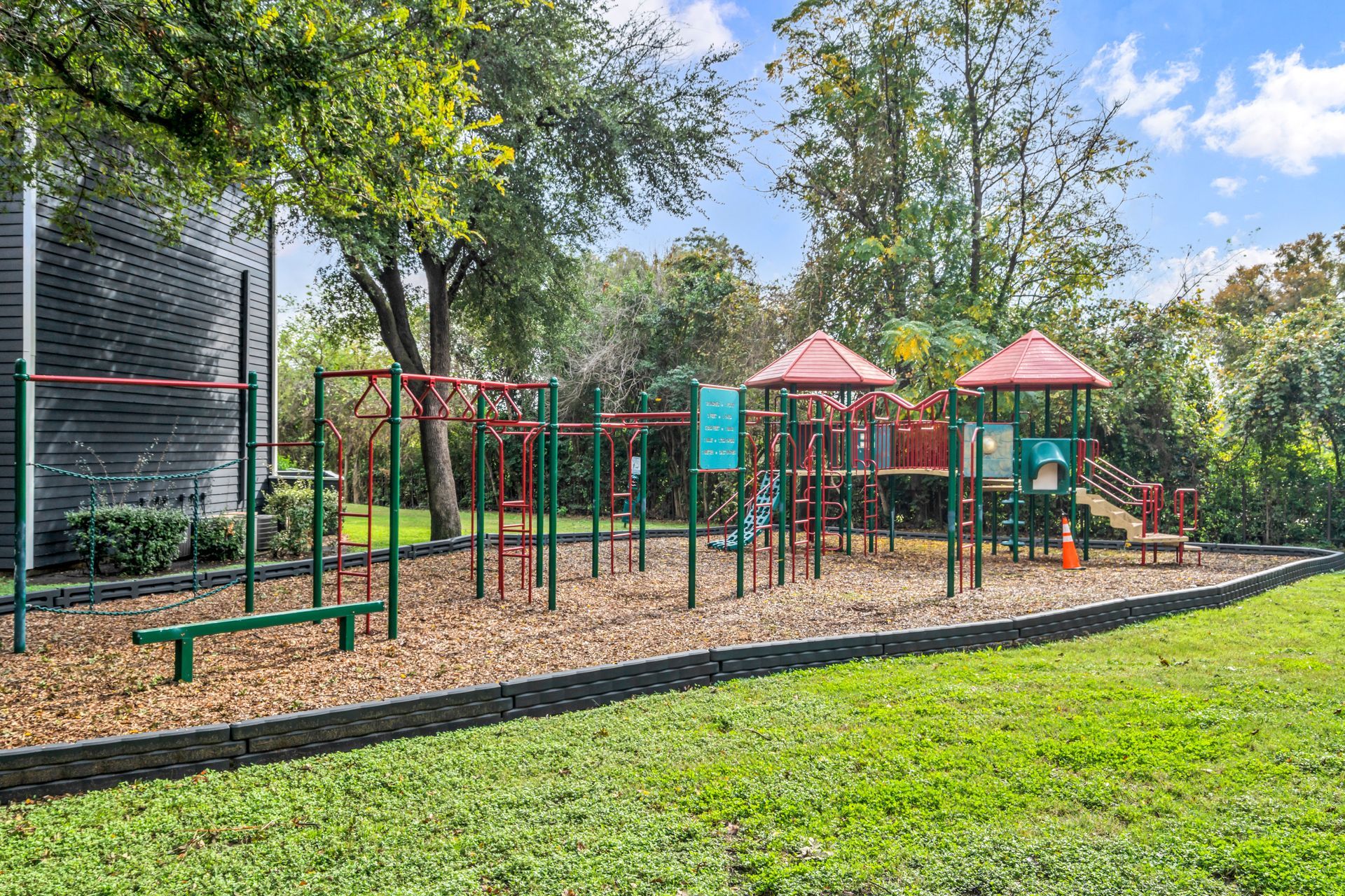 A playground in a park with trees in the background.
