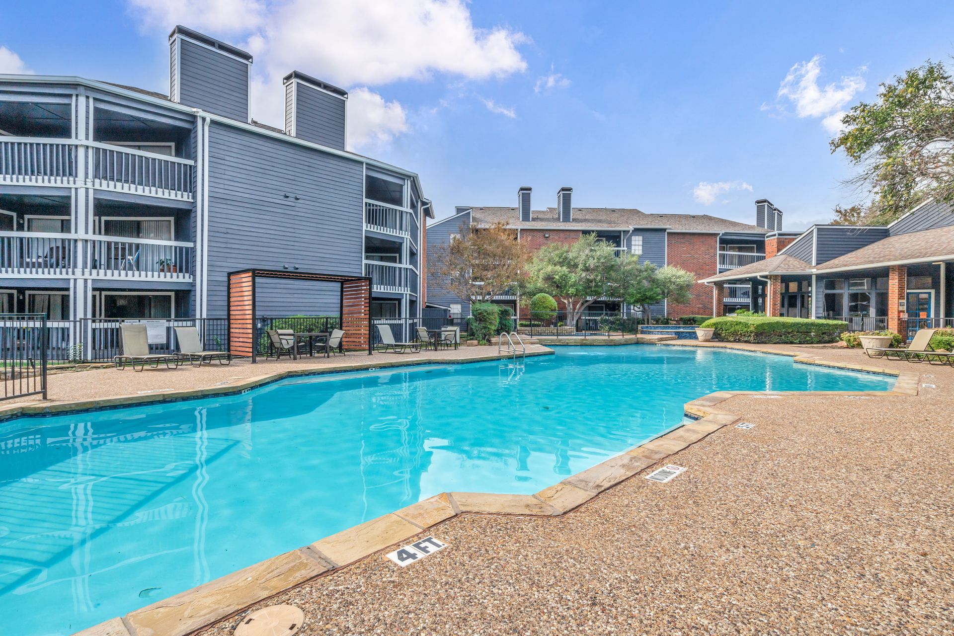 A large swimming pool in front of a building in a residential area.
