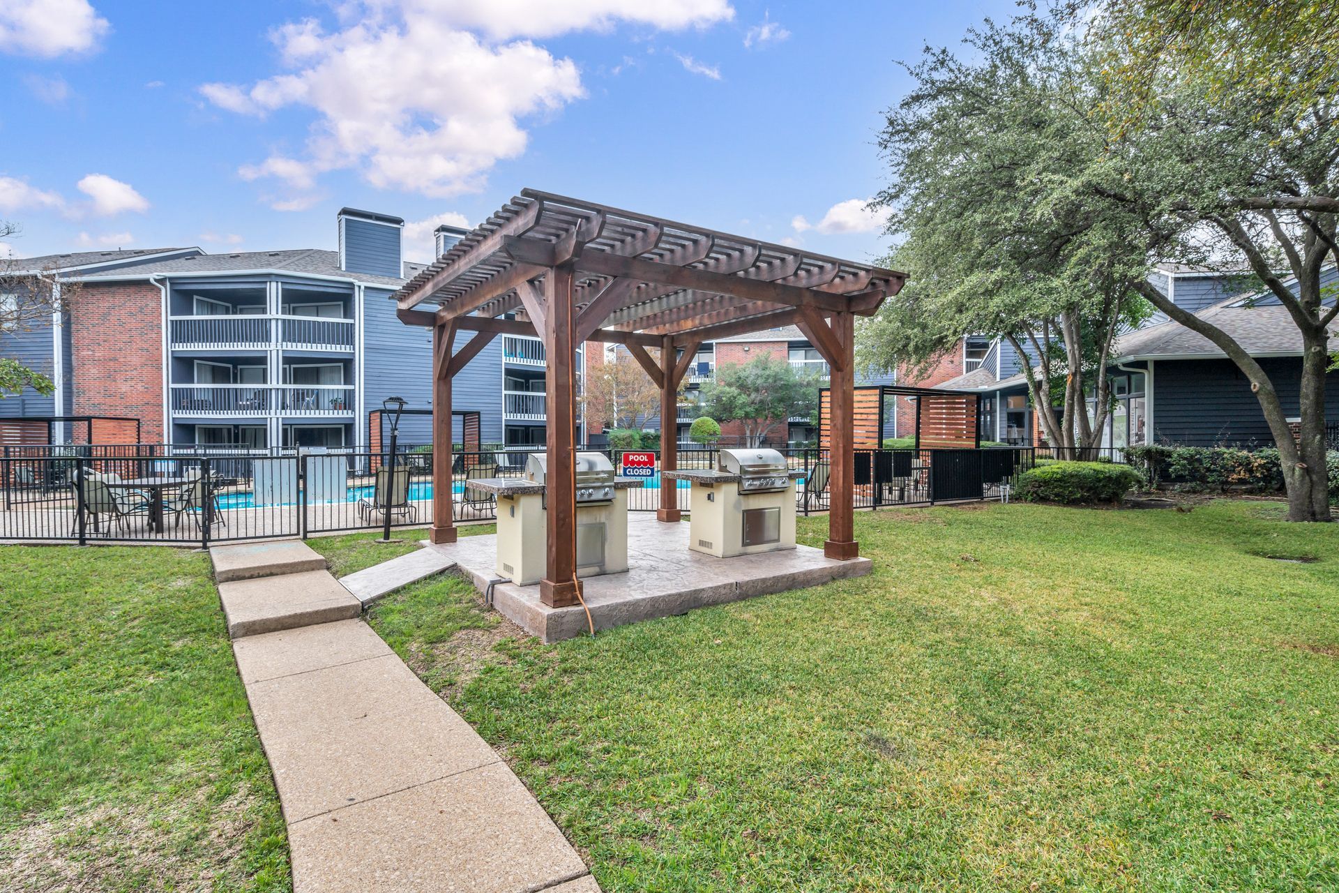 There is a gazebo in the middle of a lush green field.