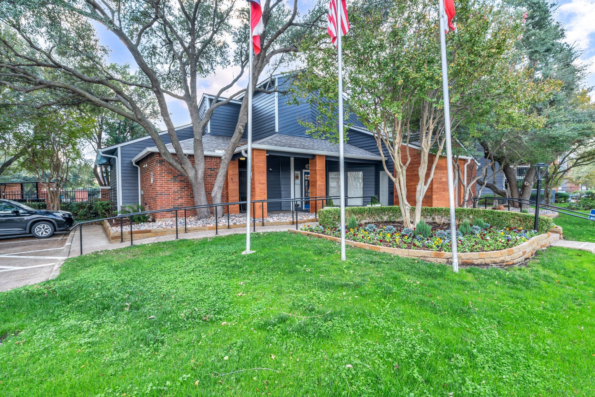 A house with a lot of grass and trees in front of it.