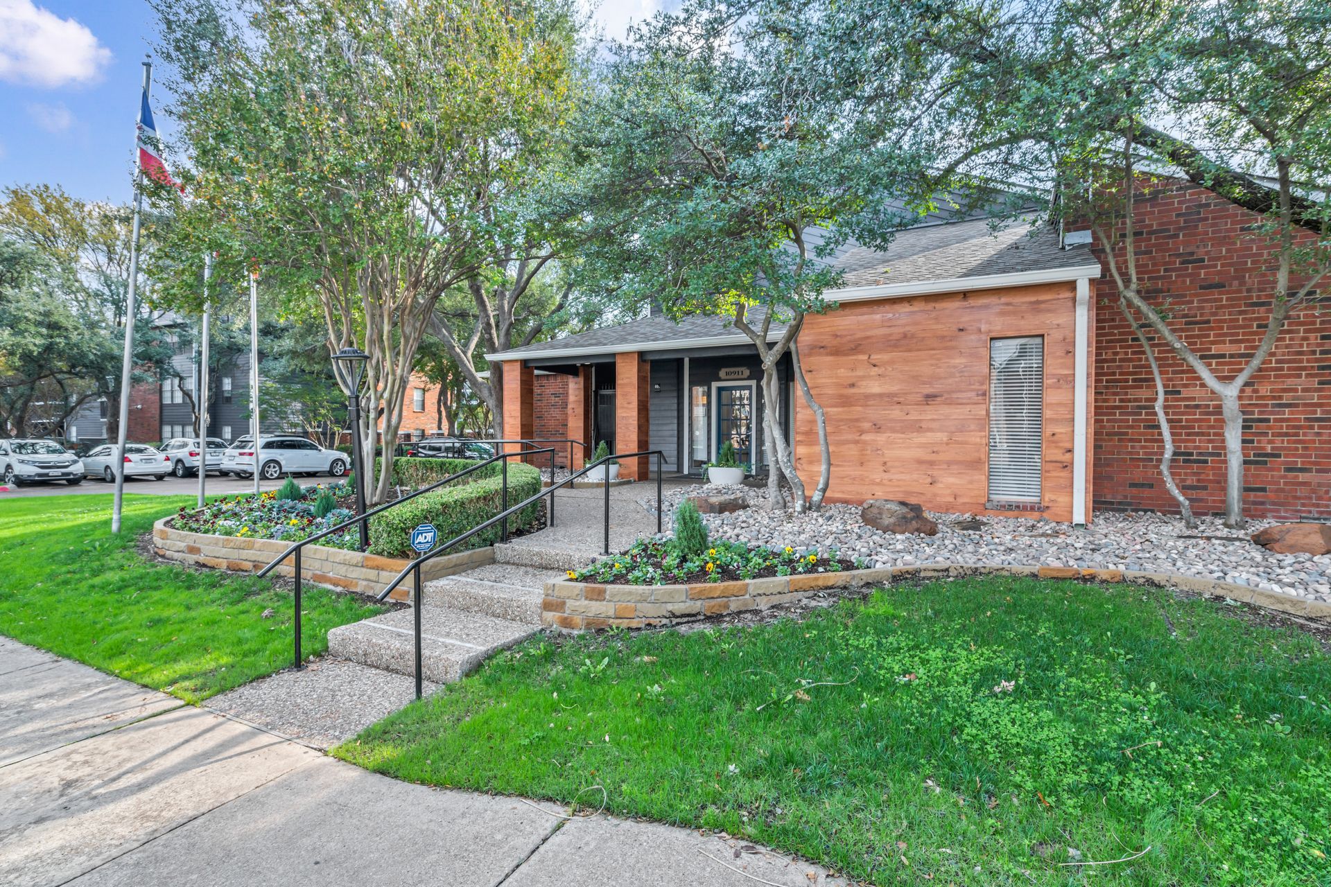 A brick building with a lush green lawn in front of it.