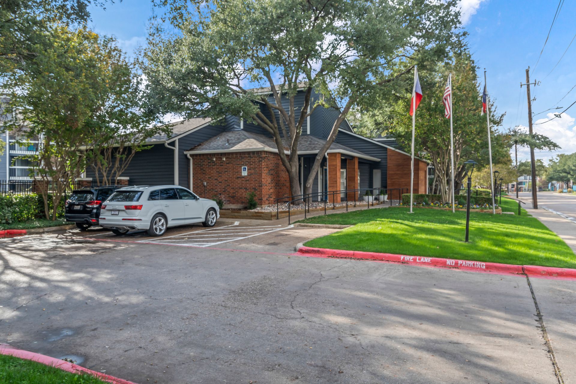 A white car is parked in front of a building.
