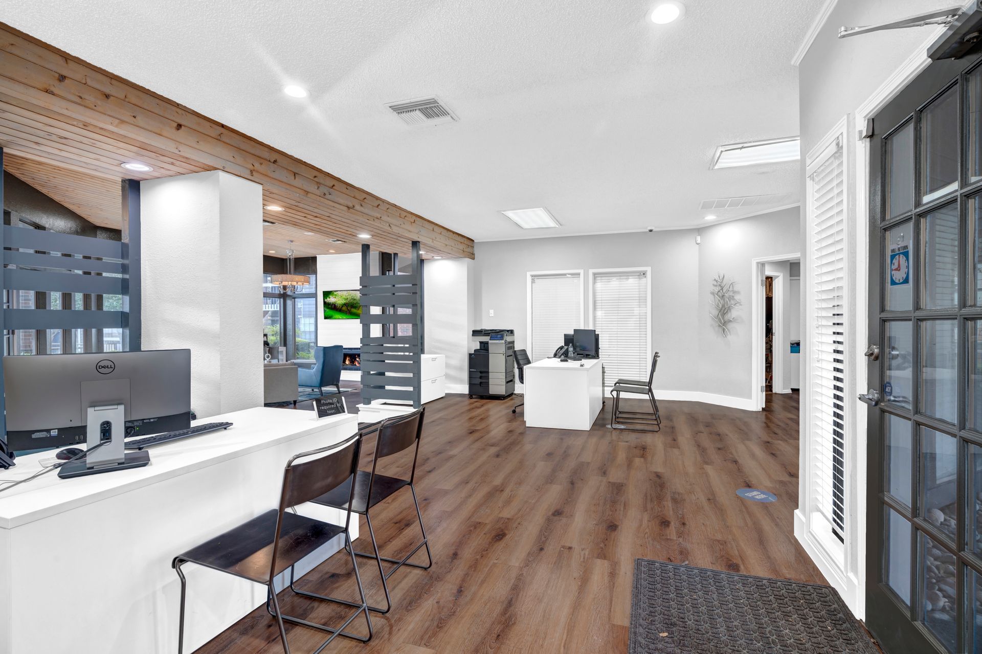 A large room with wooden floors and a desk with a computer on it.