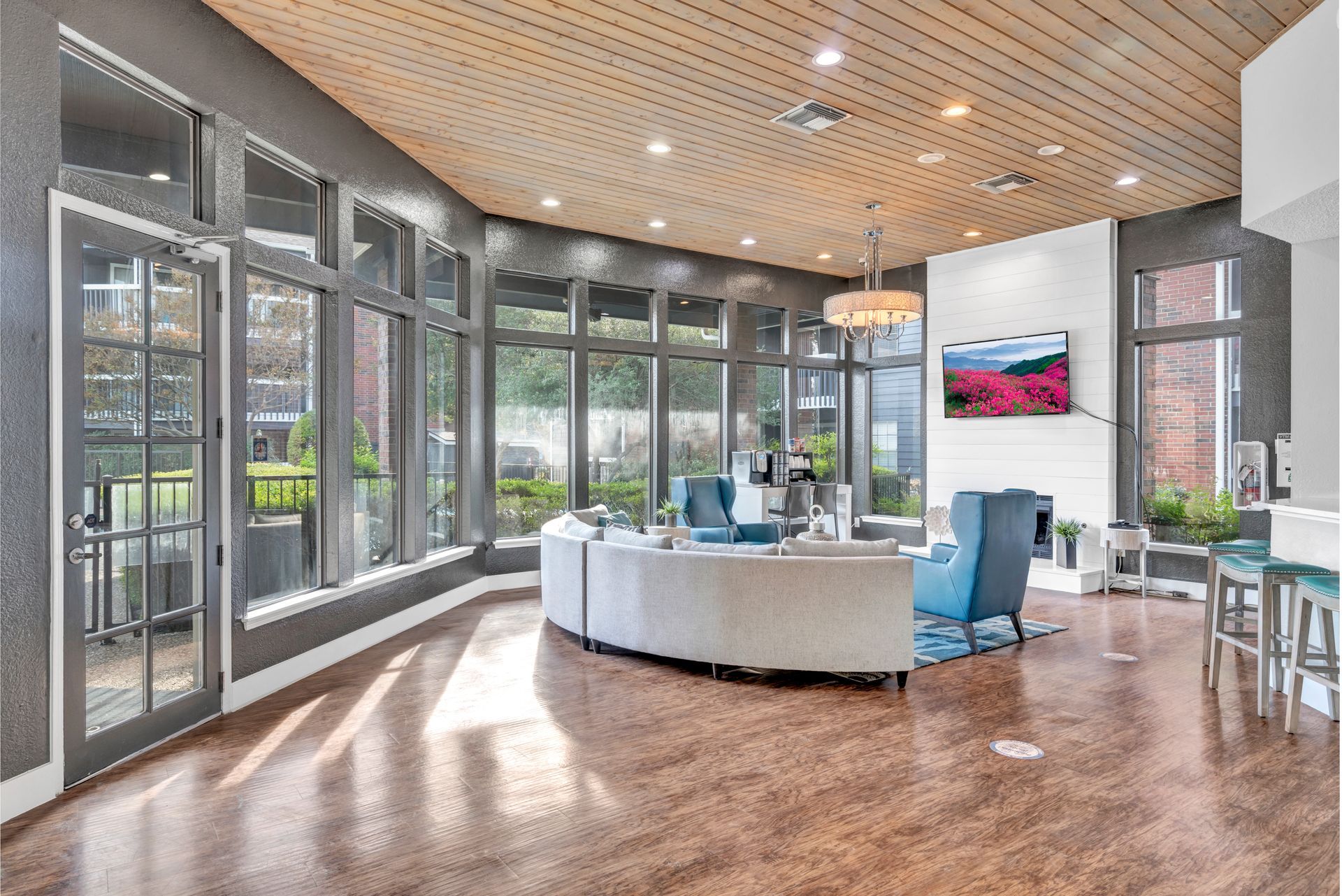 A large living room with a lot of windows and furniture.