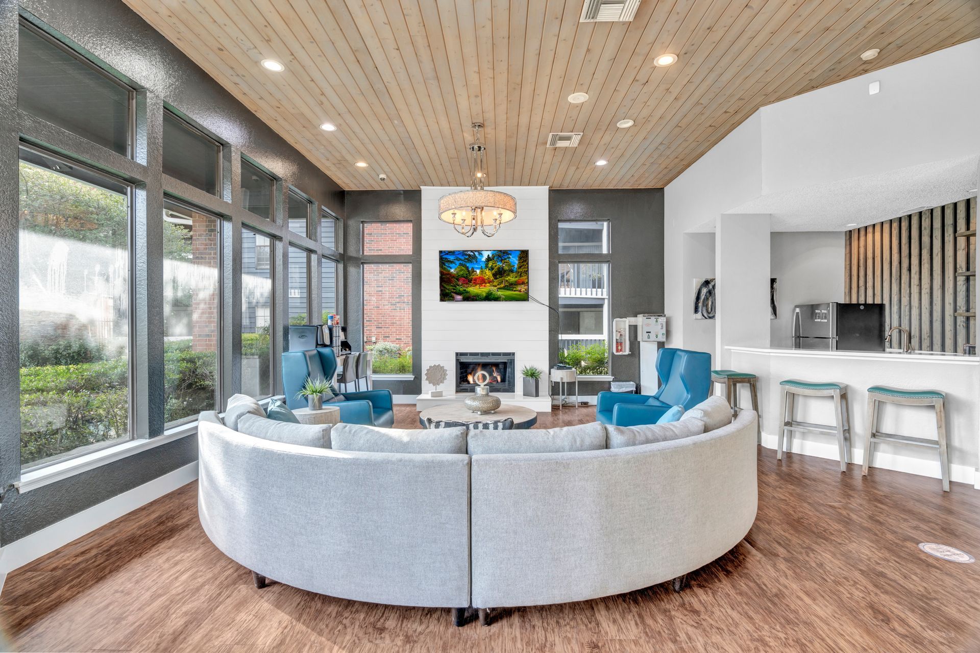 A living room with a large round couch and a fireplace.