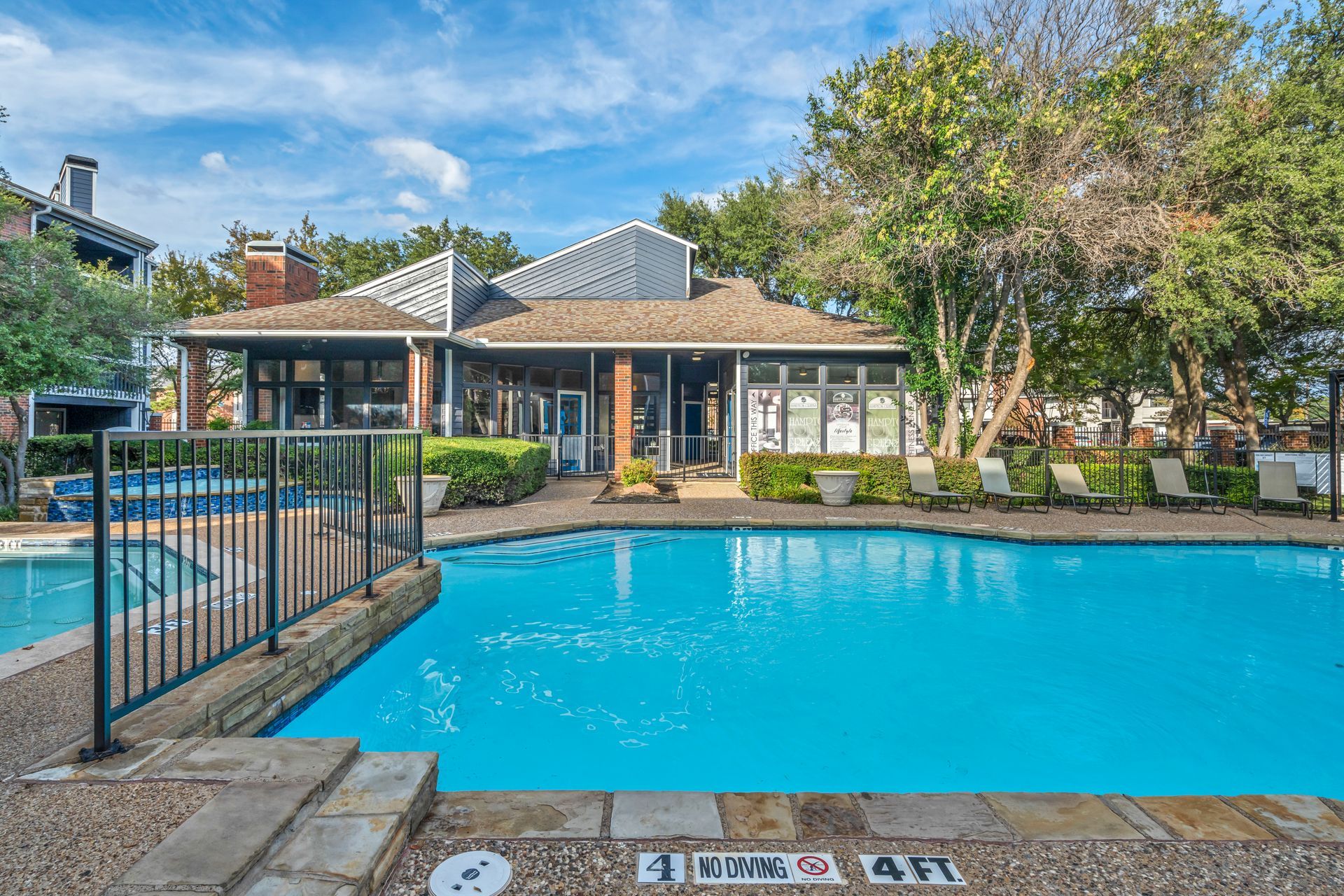 There is a large swimming pool in front of a building.