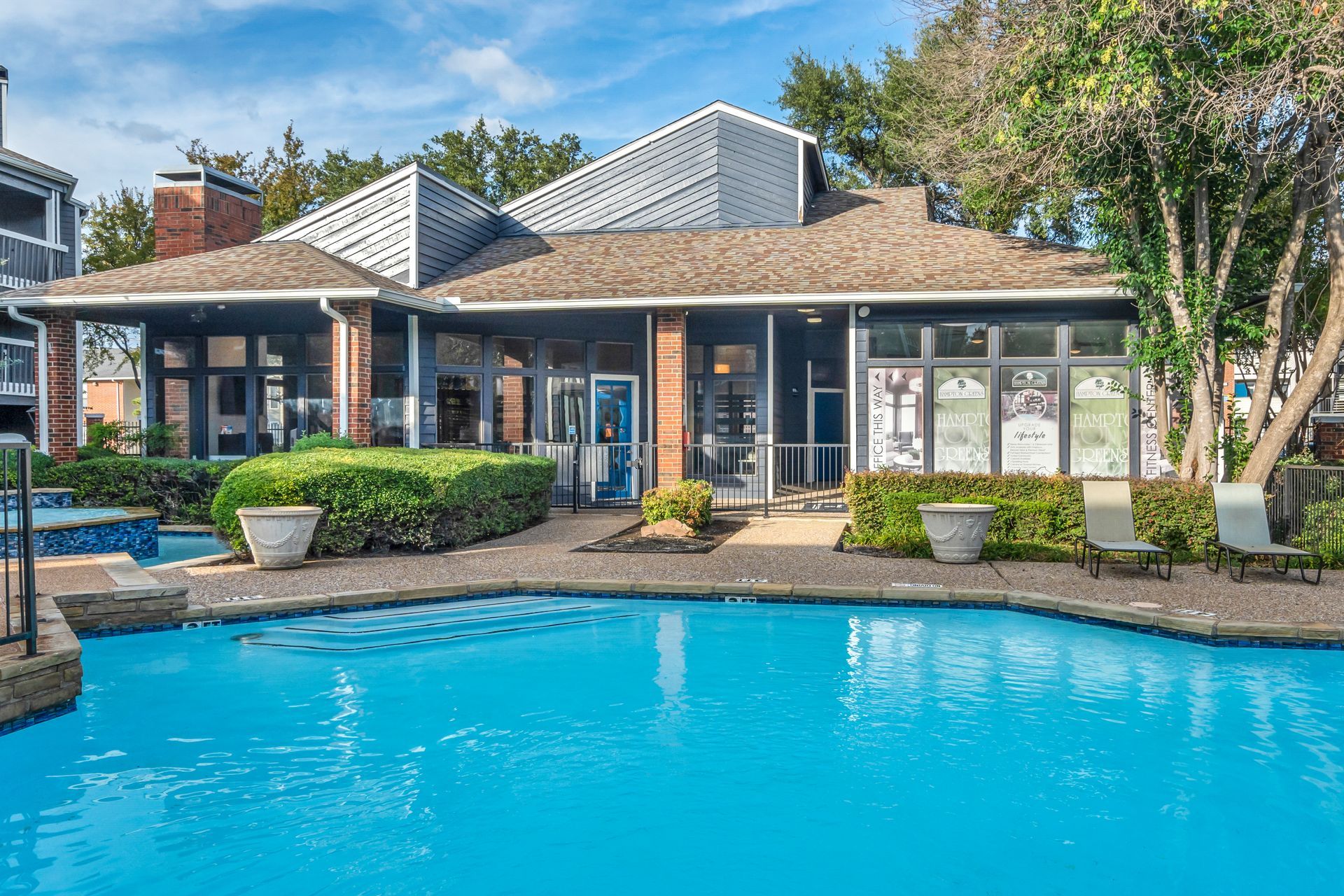 There is a large swimming pool in front of a house.