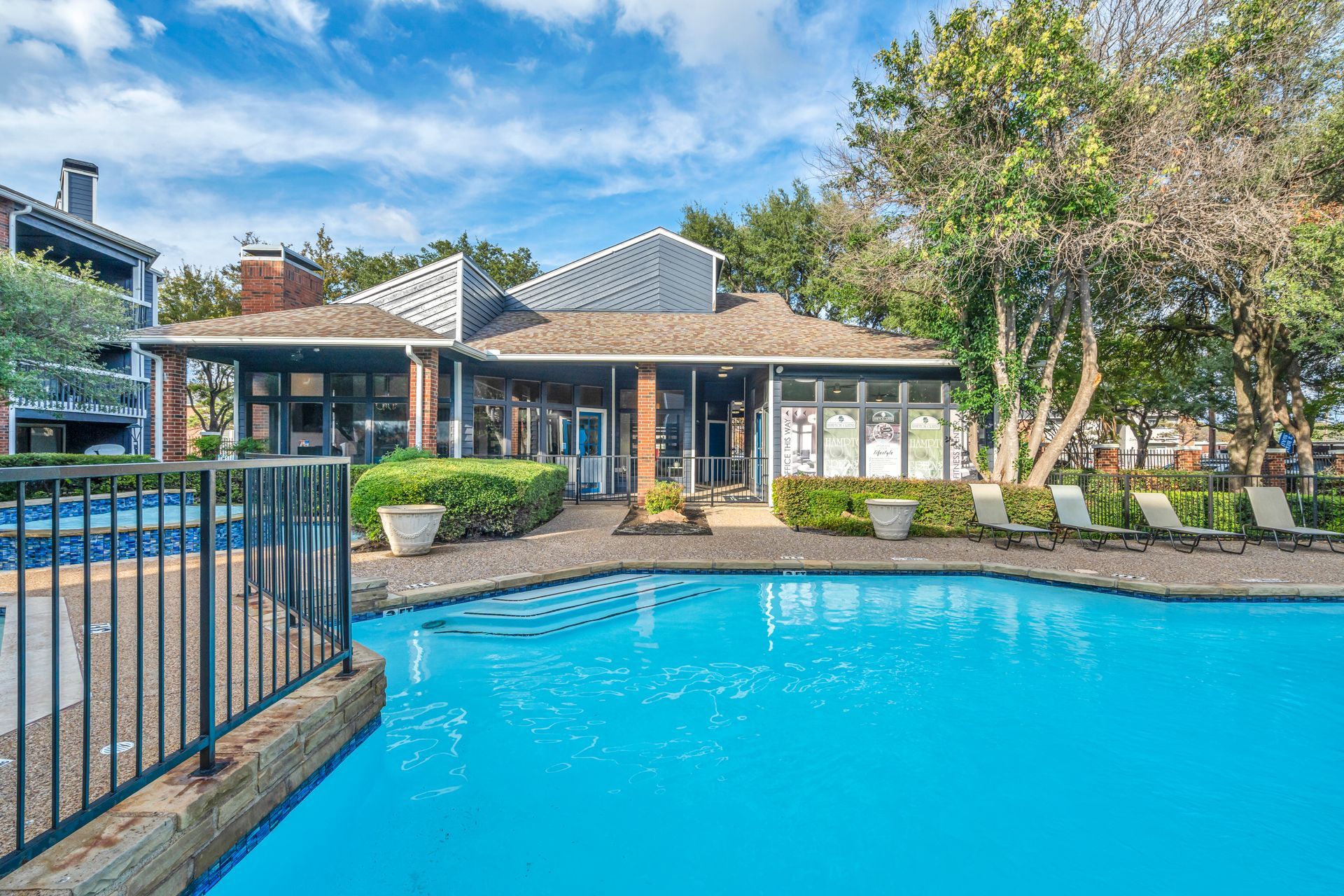 There is a large swimming pool in front of a house.